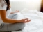 Frau meditiert zum Einschlafen im Bett